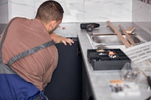 a handy man doing some kitchen cabinet refacing 