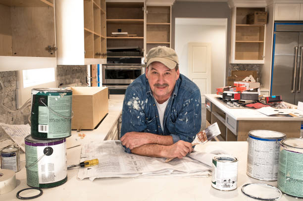 Male painter working on the new paint for the kitchen area.