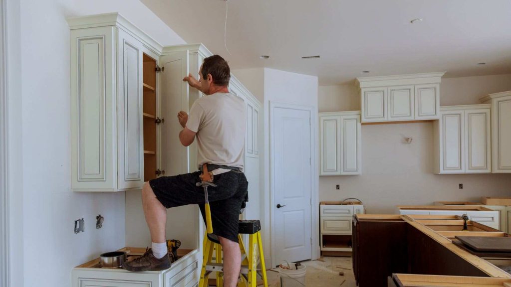 Man installing kitchen cabinets door